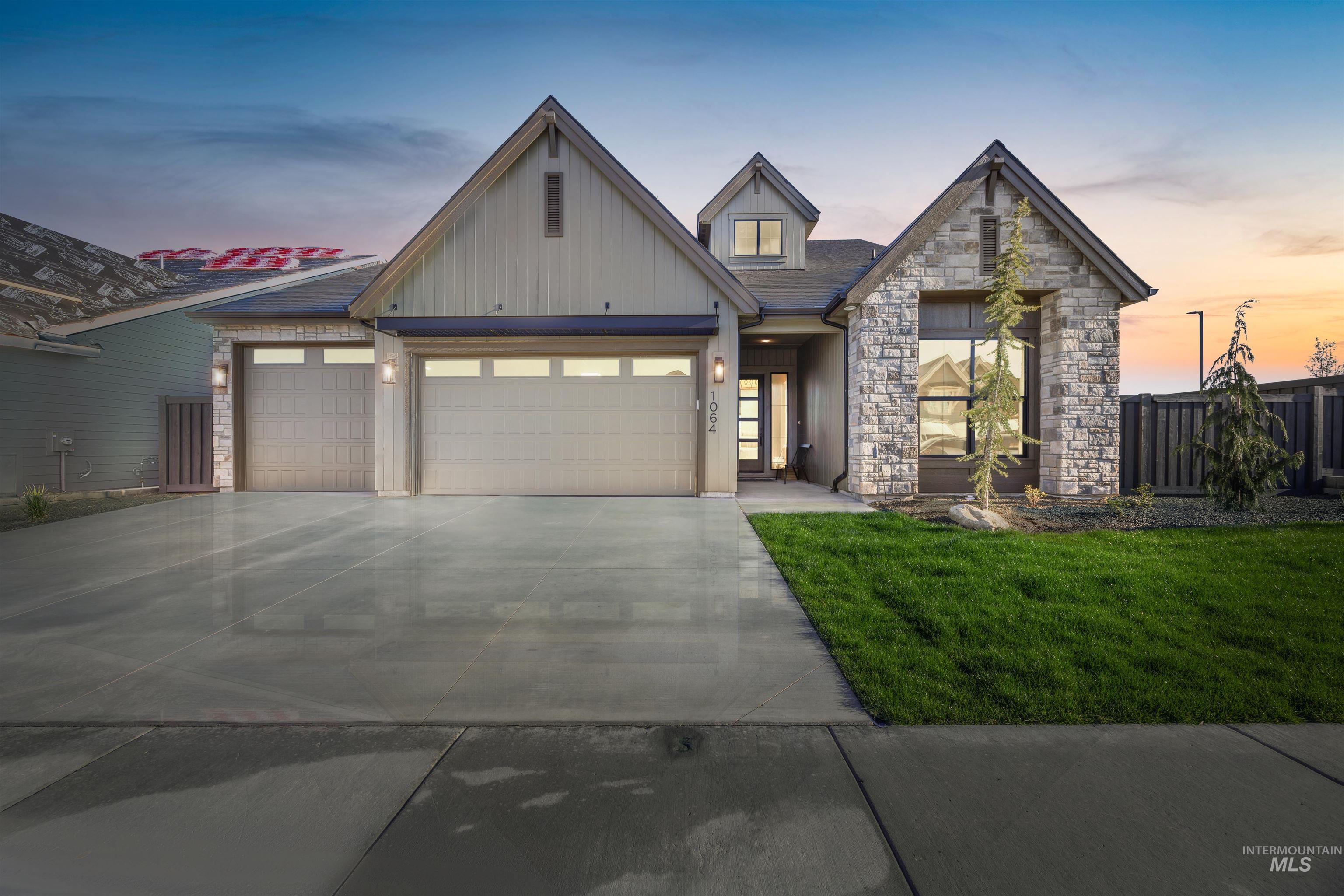 View of front of property featuring an attached garage, stone siding, and concrete driveway