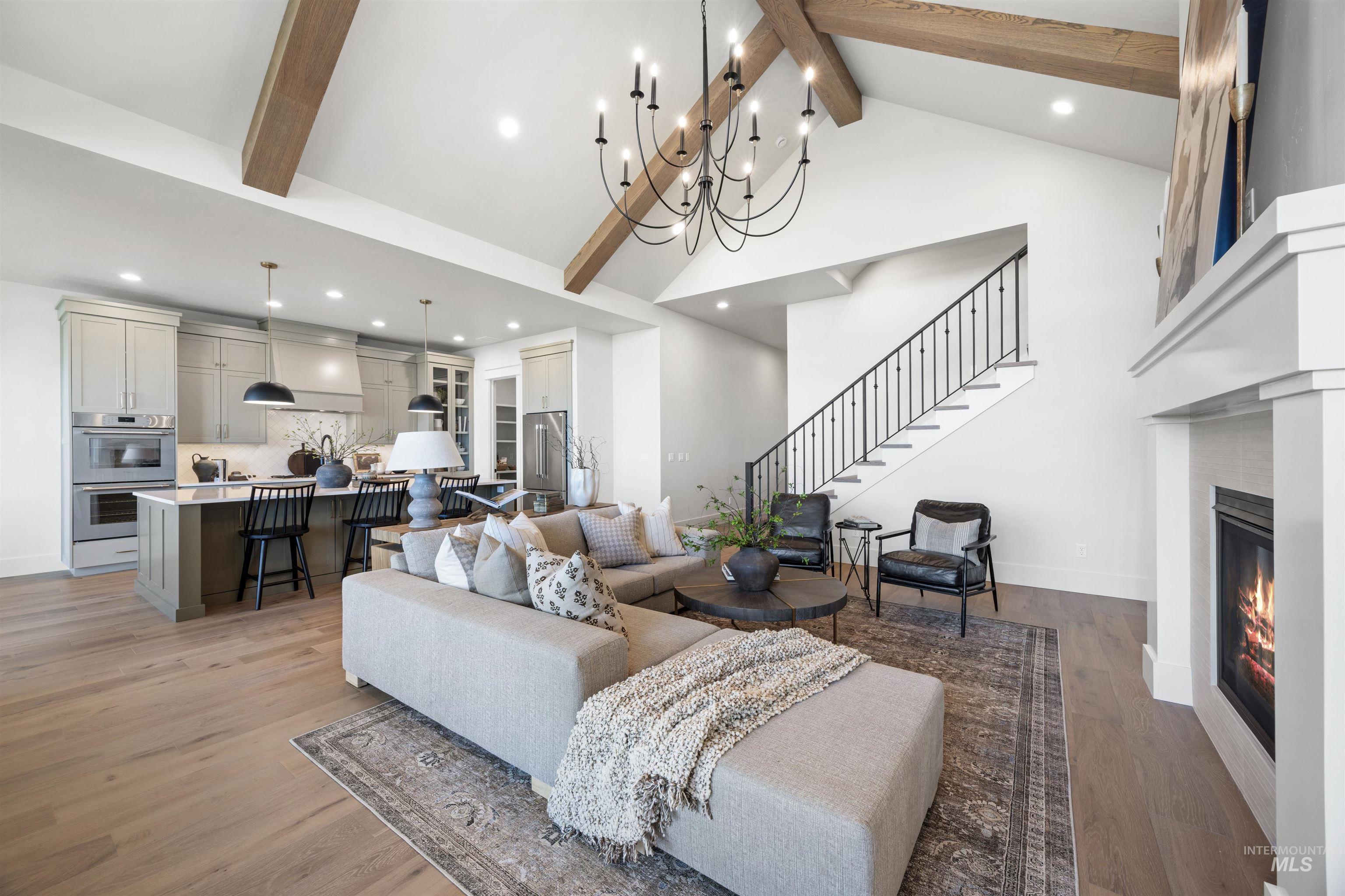 1064 East Snag Street Meridian, ID 83642 - Photo 12 of 44 Living room with light wood-style floors, a glass covered fireplace, and suspended lighting