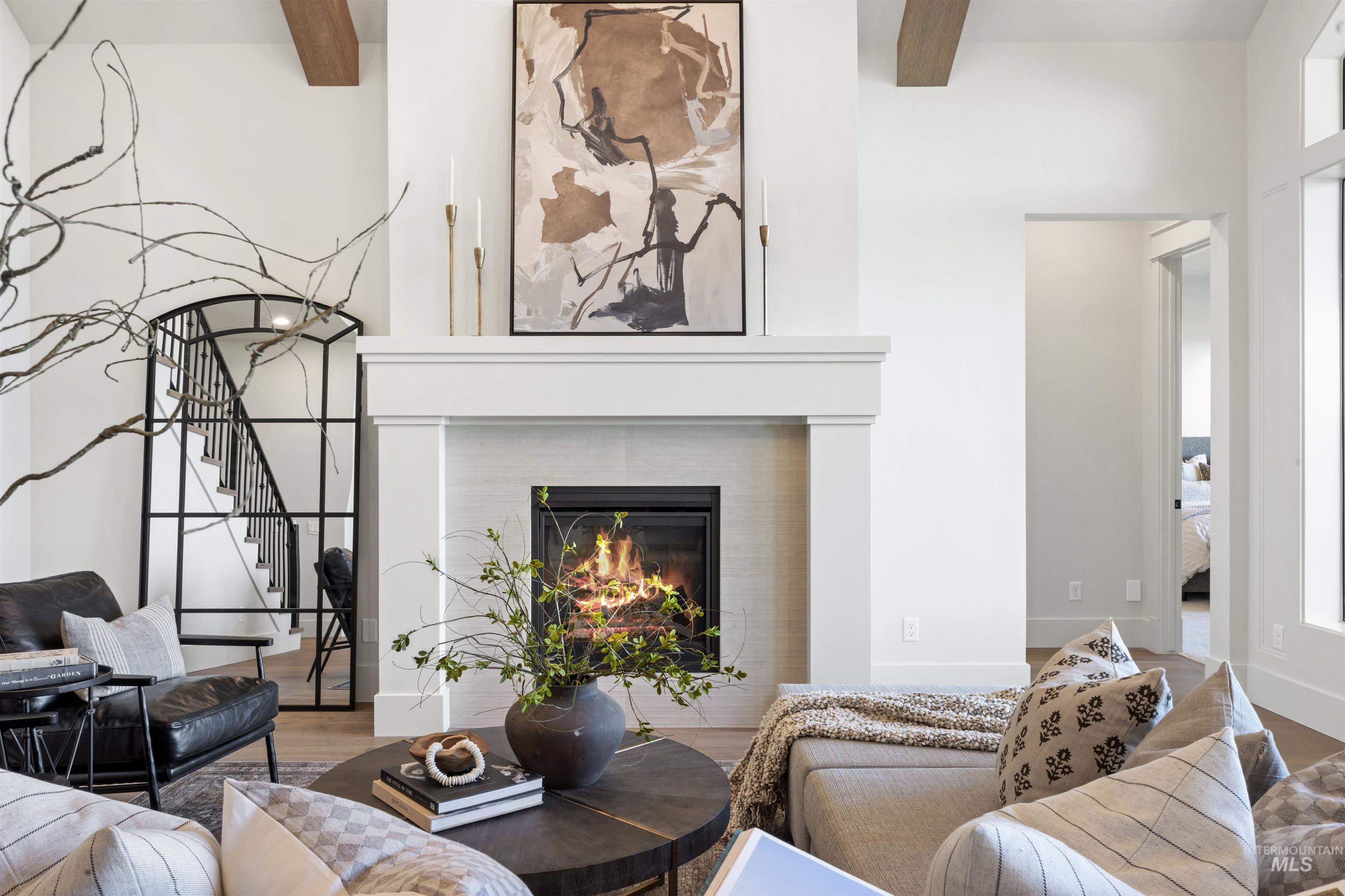 1064 East Snag Street Meridian, ID 83642 - Photo 14 of 44 Living area featuring a fireplace, wood finished floors, and beamed ceiling