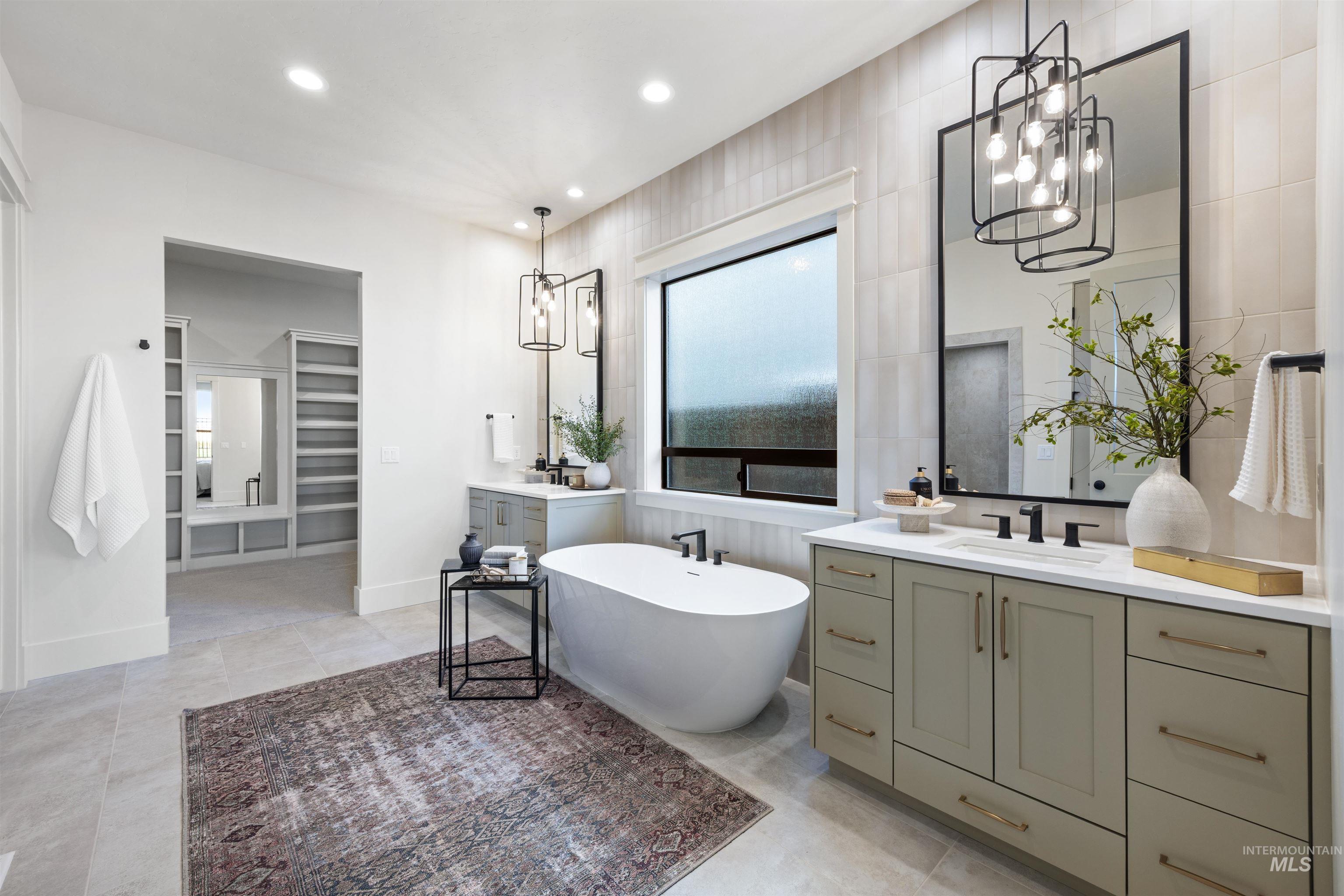 1064 East Snag Street Meridian, ID 83642 - Photo 29 of 44 Bathroom featuring a spacious closet, a freestanding tub, two vanities, and a chandelier