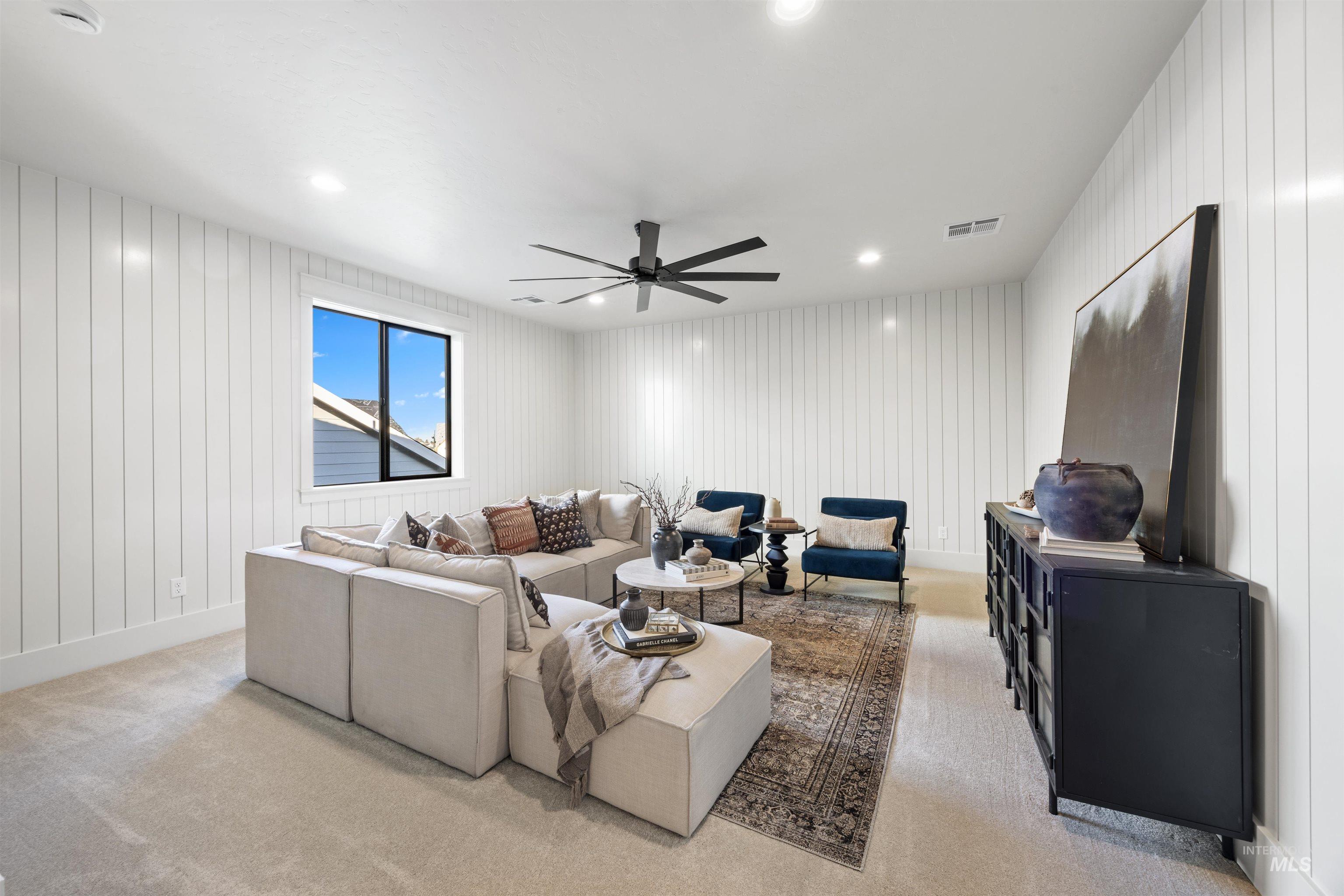 1064 East Snag Street Meridian, ID 83642 - Photo 39 of 44 Living area featuring ceiling fan, wooden walls, light colored carpet, and recessed lighting