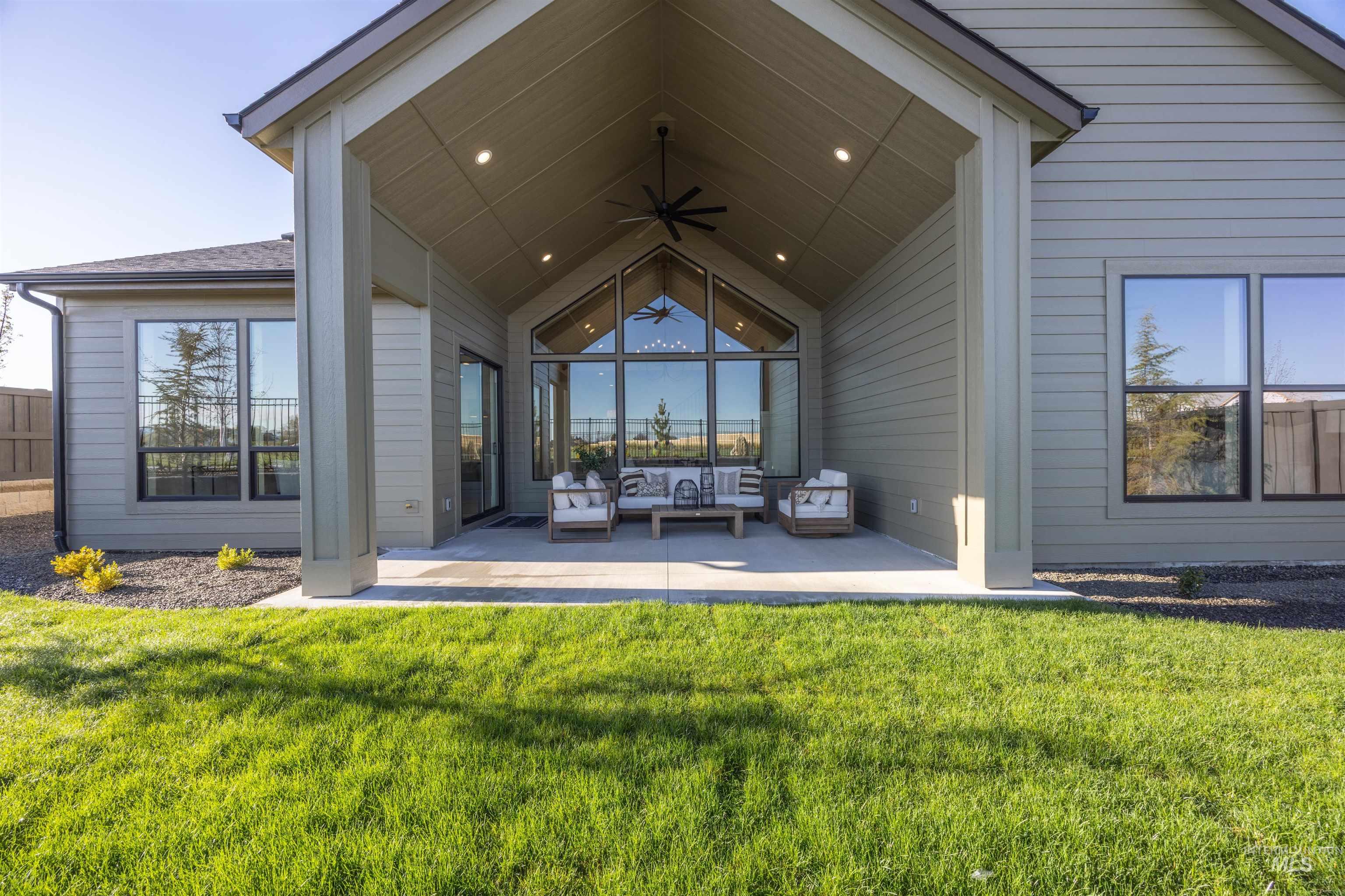 1064 East Snag Street Meridian, ID 83642 - Photo 42 of 44 Back of property featuring ceiling fan, a yard, a patio area, and an outdoor hangout area