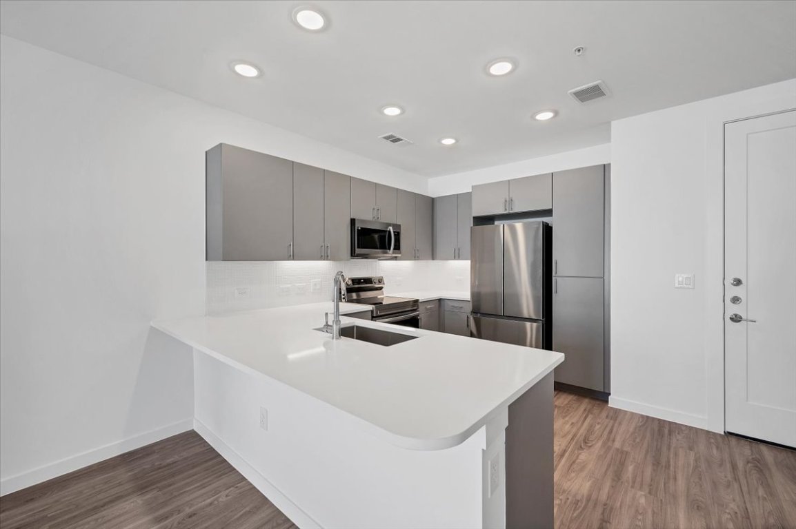 4801 Springdale Road, Unit 1402 Austin, TX 78723 - Photo 12 of 40 a kitchen with refrigerator cabinets and wooden floor