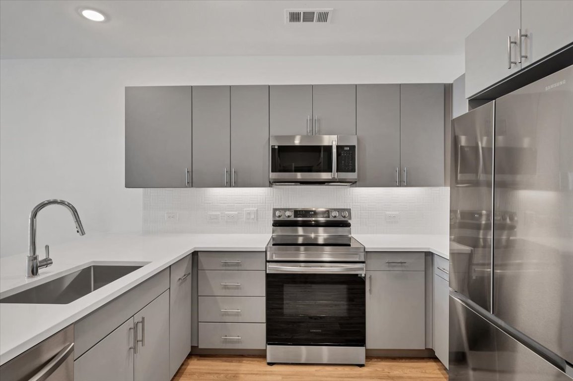 4801 Springdale Road, Unit 1402 Austin, TX 78723 - Photo 13 of 40 a kitchen with a sink stove and refrigerator