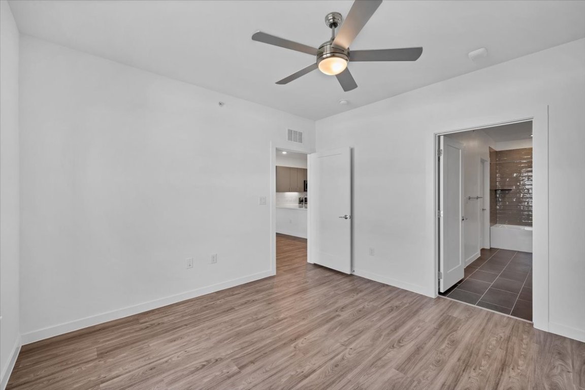 4801 Springdale Road, Unit 1402 Austin, TX 78723 - Photo 16 of 40 an empty room with wooden floor and ceiling fan