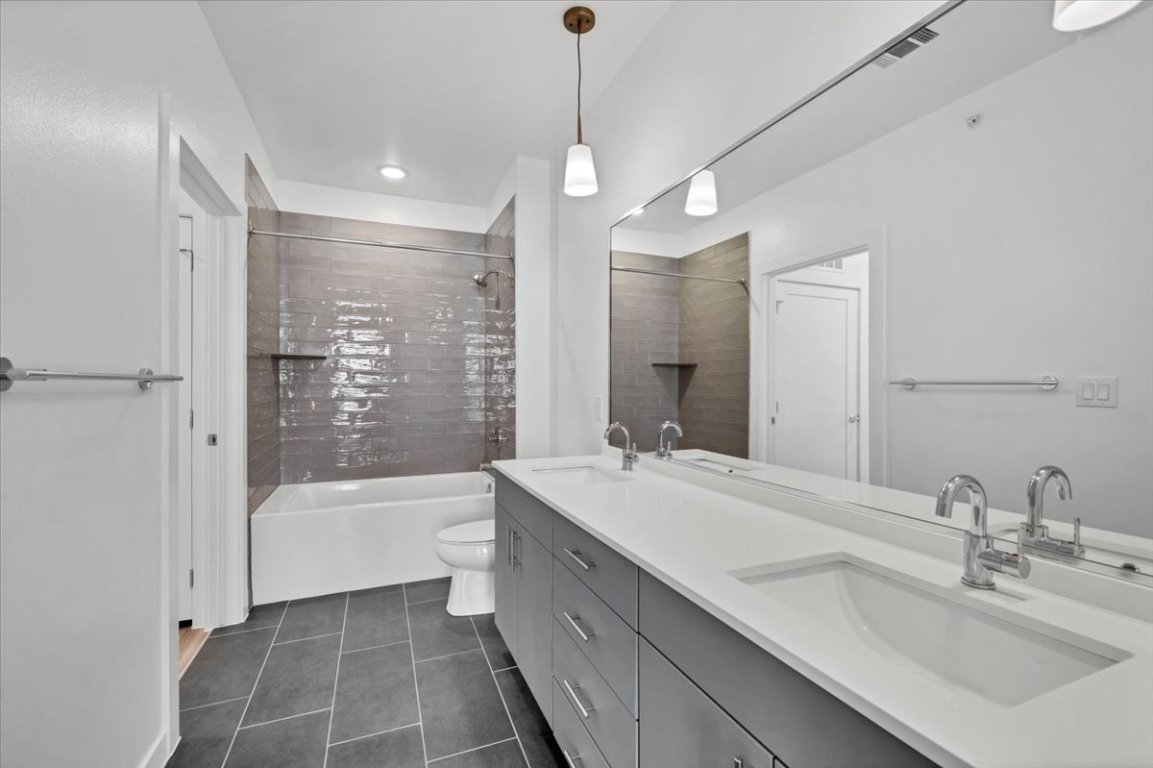 4801 Springdale Road, Unit 1402 Austin, TX 78723 - Photo 17 of 40 a bathroom with a tub sink shower and a mirror