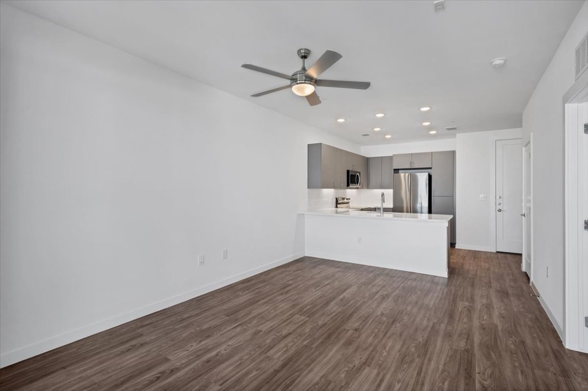 4801 Springdale Road, Unit 1402 Austin, TX 78723 - Photo 8 of 40 a view of a kitchen with wooden floor and a ceiling fan
