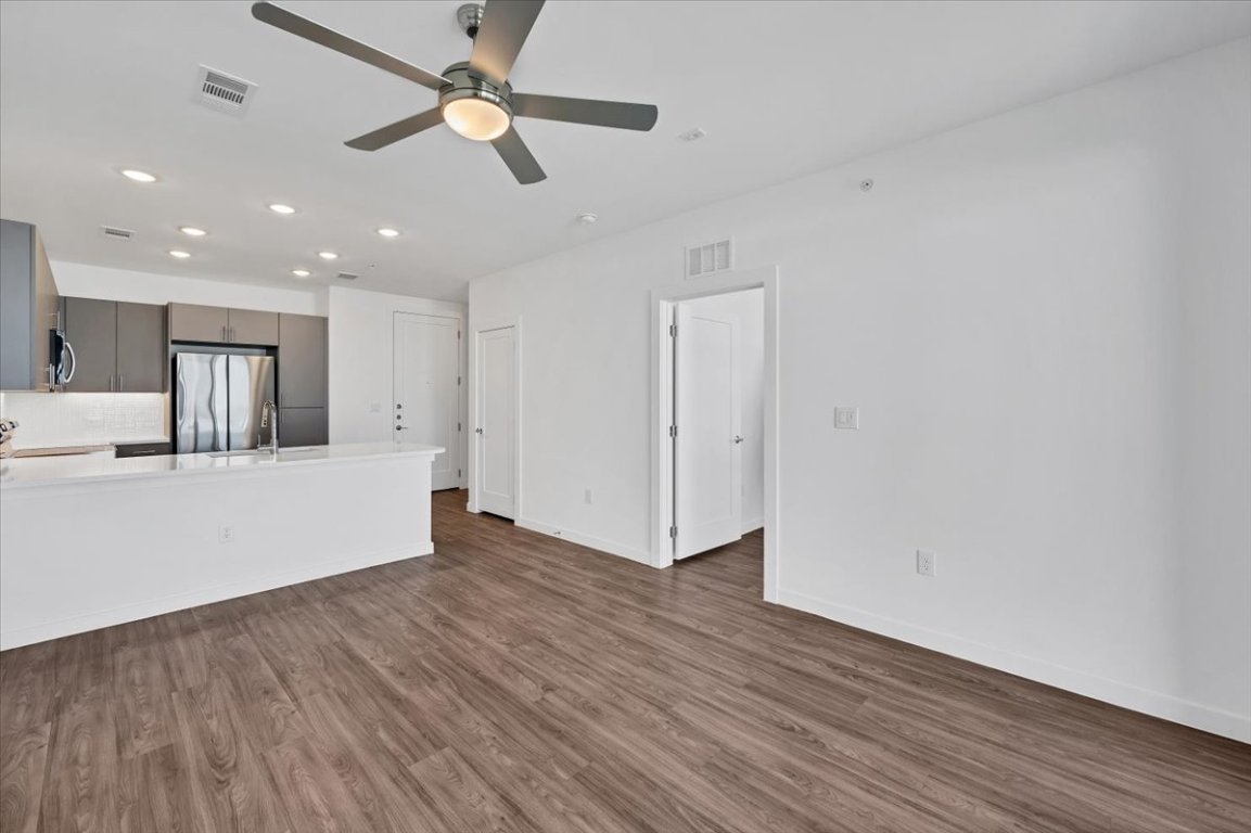 4801 Springdale Road, Unit 1402 Austin, TX 78723 - Photo 9 of 40 a view of an empty room with wooden floor and a ceiling fan