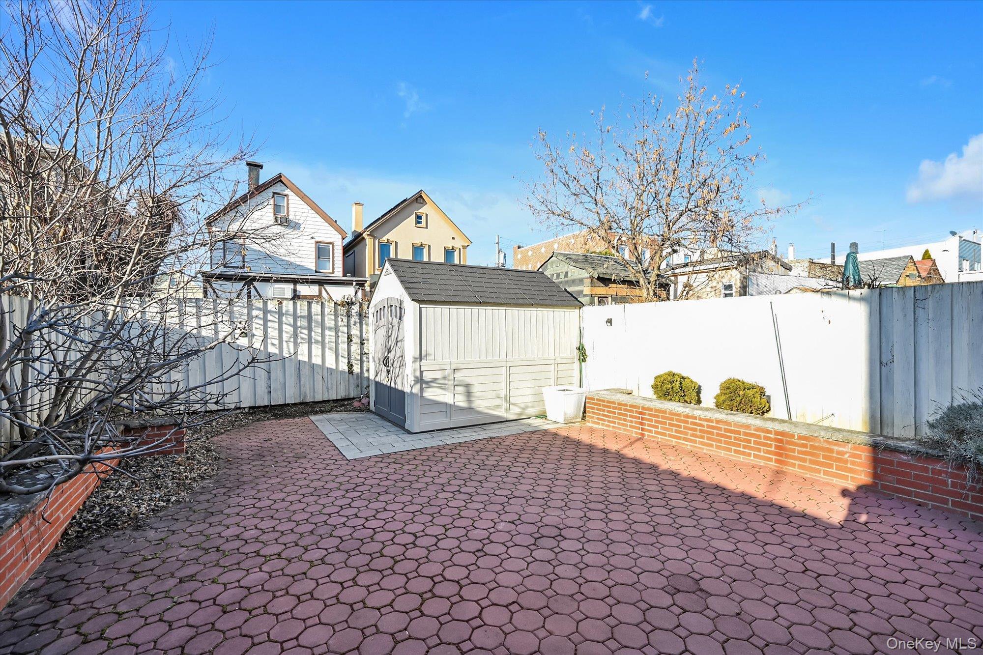 69-25 59th Road Queens, NY 11378 - Photo 22 of 24 Fenced backyard featuring a shed and a patio
