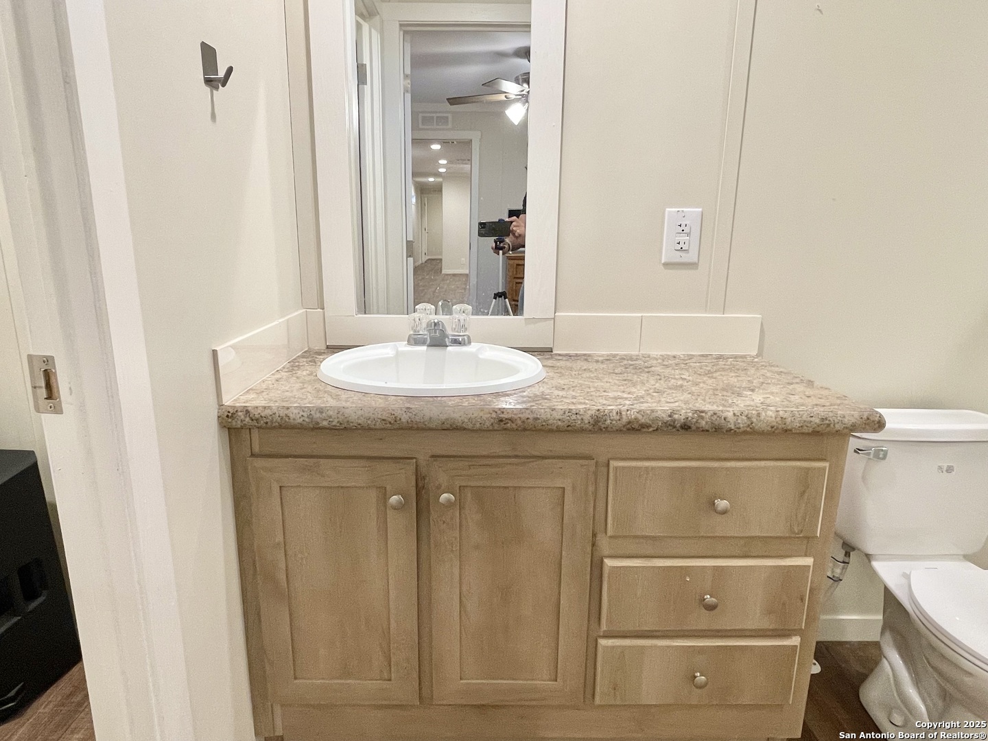 7970 1st Street Somerset, TX 78069 - Photo 30 of 32 a bathroom with a granite countertop sink and a mirror