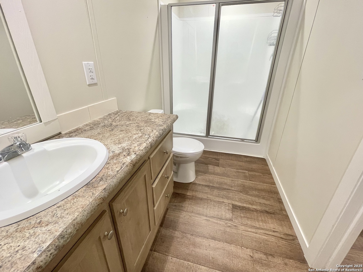 7970 1st Street Somerset, TX 78069 - Photo 32 of 32 a bathroom with a granite countertop sink and a mirror