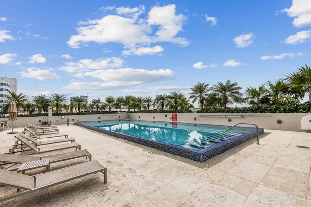 a view of a swimming pool with a patio and a yard