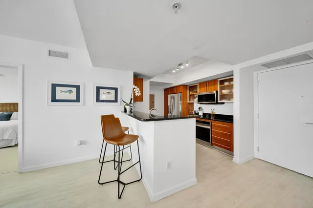 a living room with furniture a rug and kitchen view