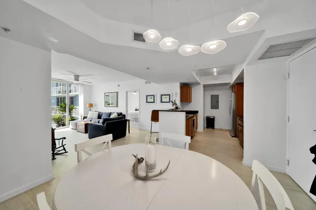 a living room with furniture kitchen and a refrigerator
