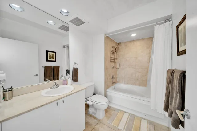 a bathroom with a sink a toilet and a large mirror