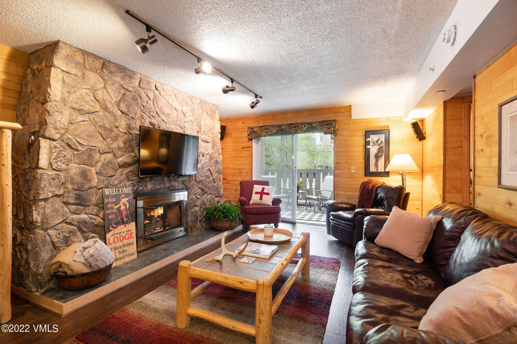 a living room with furniture a flat screen tv and a floor to ceiling window