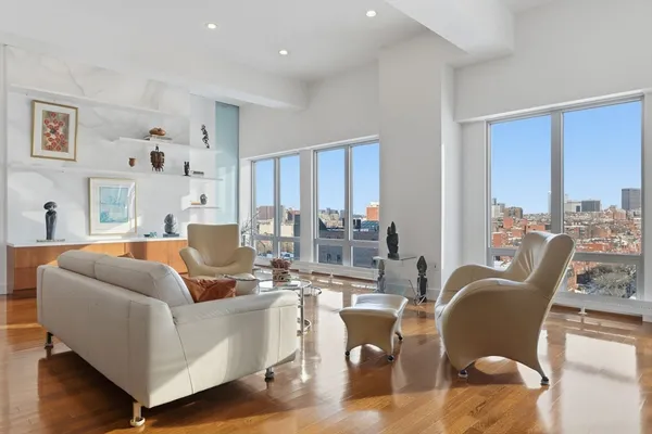 a living room with furniture potted plant and a large window