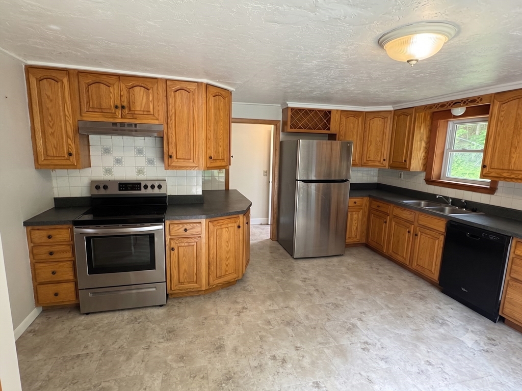 27 High Street Sturbridge, MA 01518 - Photo 8 of 17 a kitchen with a stove a sink and a refrigerator