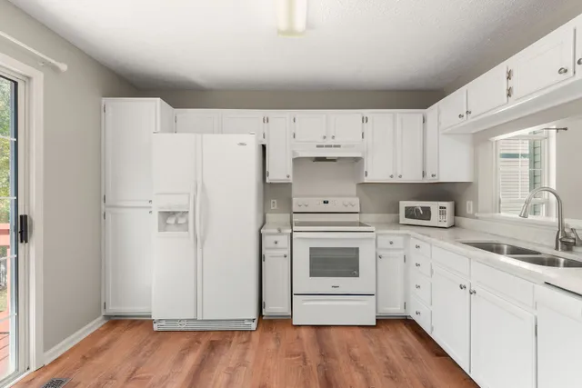 a kitchen with white cabinets and white appliances