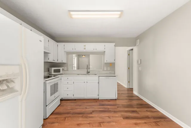 a kitchen with white cabinets and stainless steel appliances