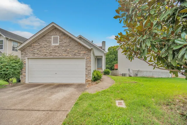 a view of a house with a yard and garage