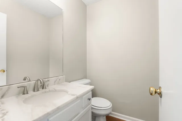 a bathroom with a toilet a sink and mirror