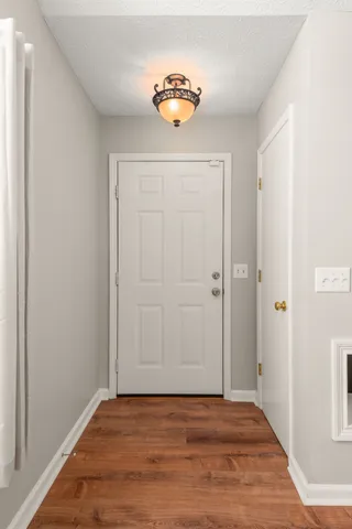 a view of a livingroom with wooden floor and a hallway