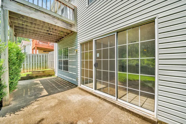 a view of a porch with a floor to ceiling window and wooden fence