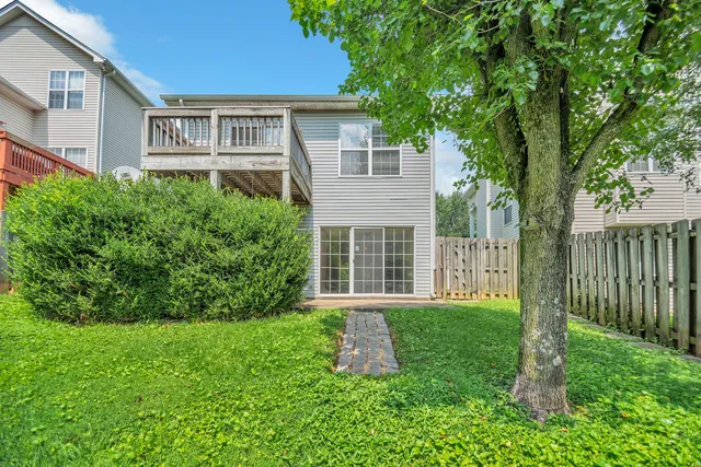 a front view of a house with a yard and trees