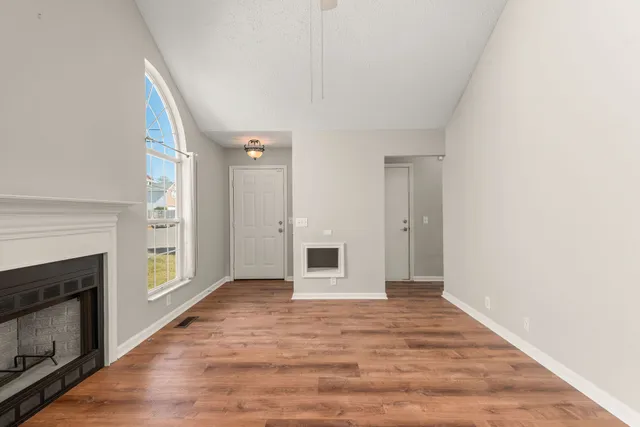 a view of a livingroom with a fireplace wooden floor and window