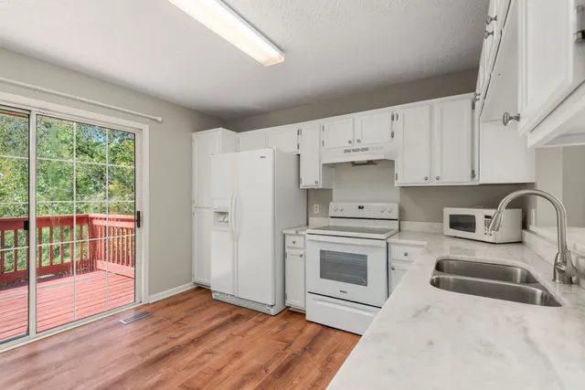 a kitchen with stainless steel appliances white cabinets and a refrigerator