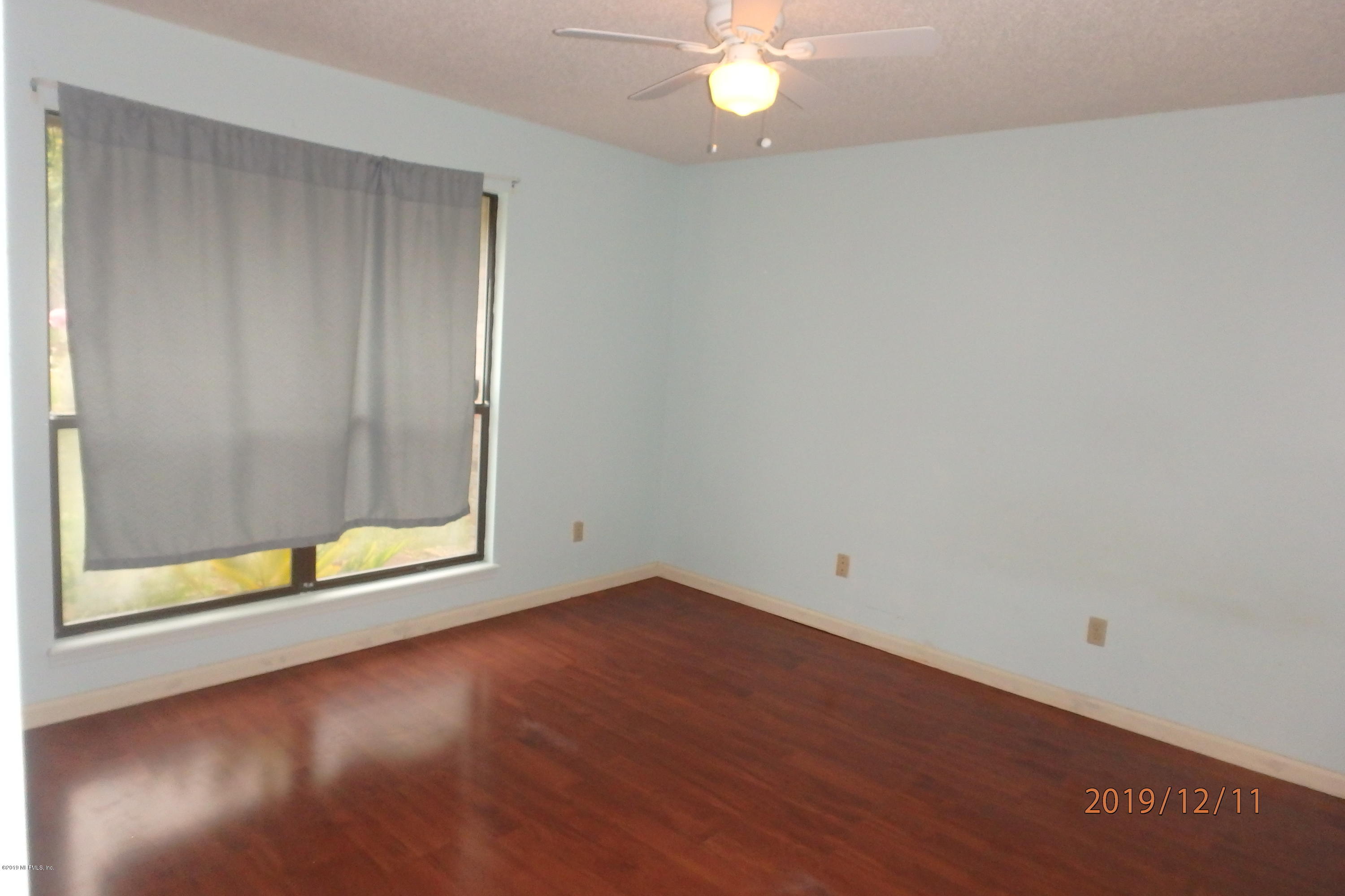2064 Derringer Road Jacksonville, FL 32225 - Photo 13 of 17 an empty room with a chandelier fan and windows