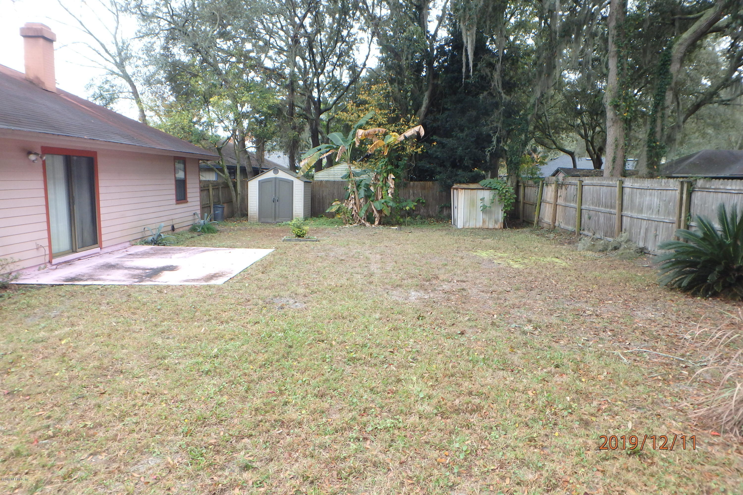 2064 Derringer Road Jacksonville, FL 32225 - Photo 16 of 17 a backyard of a house with table and chairs plants and large trees