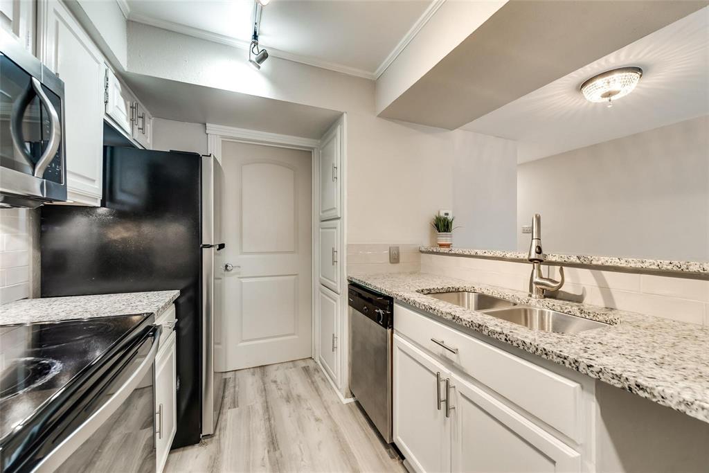 18240 Midway Road, Unit 302 Dallas, TX 75287 - Photo 12 of 33 a kitchen with stainless steel appliances granite countertop a sink and a refrigerator