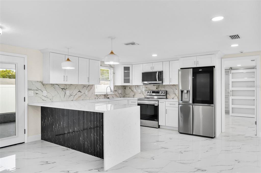 5626 Moog Road Holiday, FL 34690 - Photo 11 of 38 a kitchen with a sink stainless steel appliances and cabinets