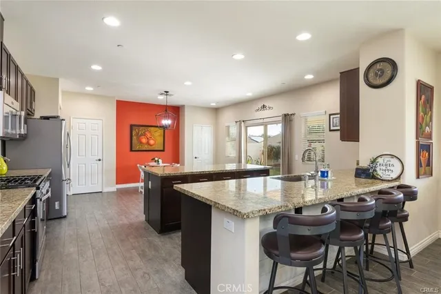 a large kitchen with granite countertop a stove a table and chairs in it