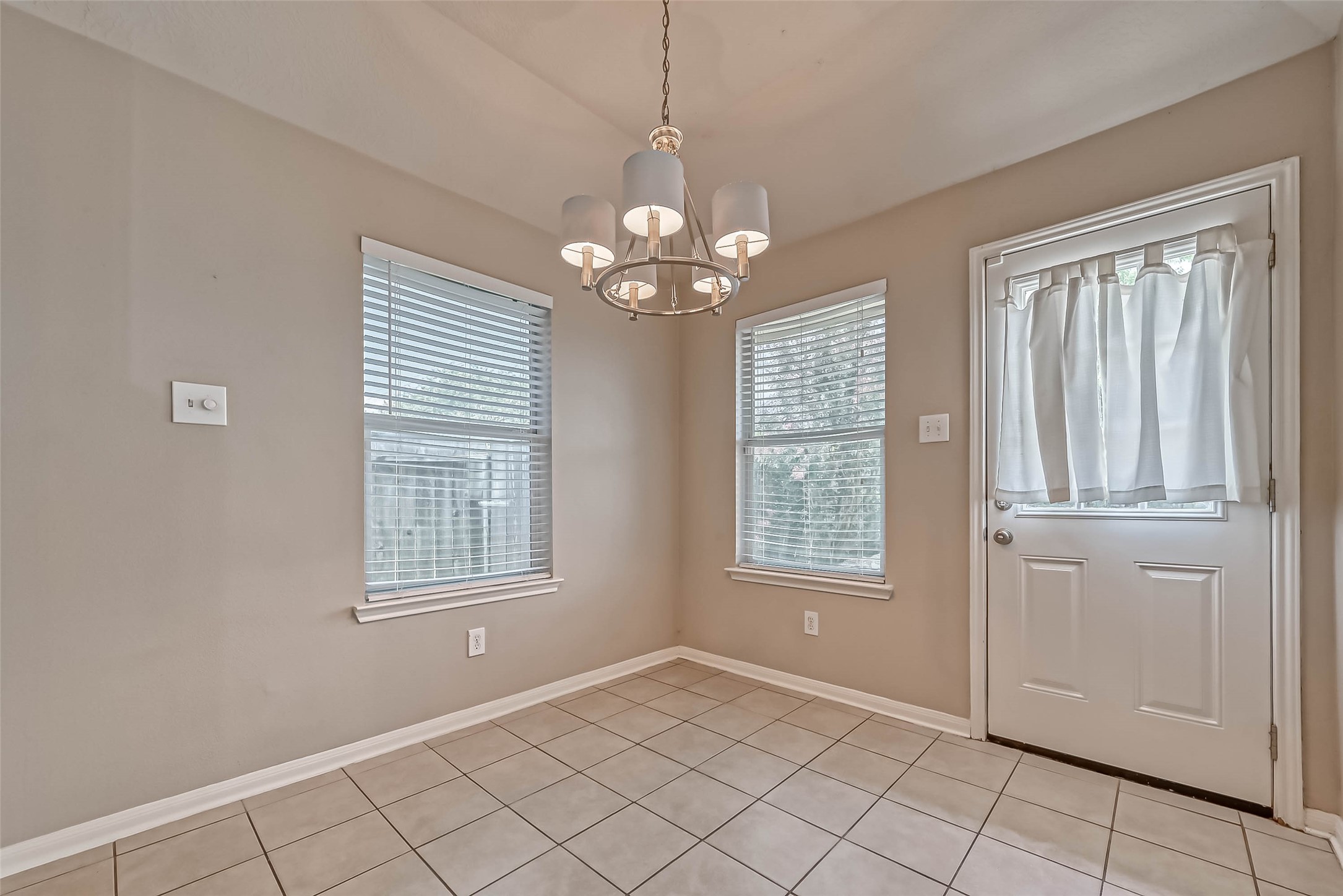 911 Bent Sail Lane League City, TX 77573 - Photo 11 of 34 an empty room with windows and chandelier