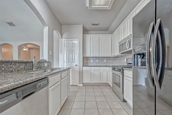 a kitchen with stainless steel appliances granite countertop a sink stove and refrigerator