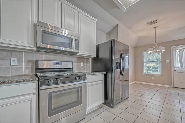 a kitchen with cabinets stainless steel appliances and a counter space
