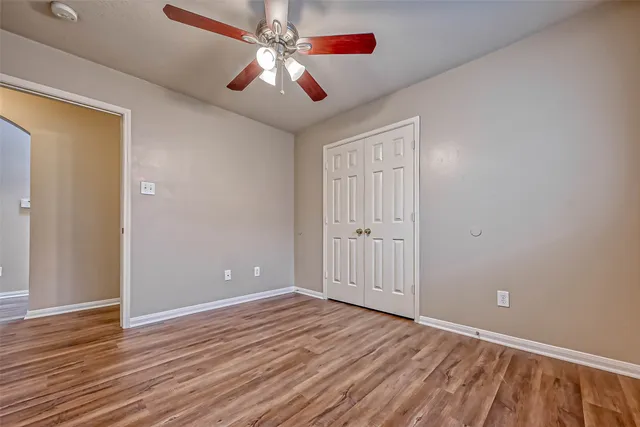 a view of empty room with wooden floor