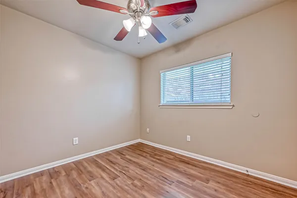 an empty room with a window and a fan