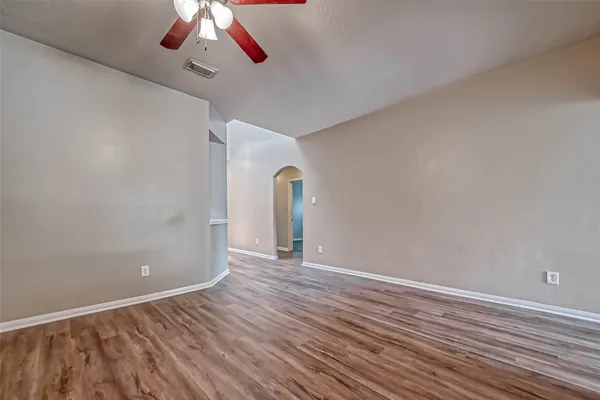 a view of empty room with wooden floor