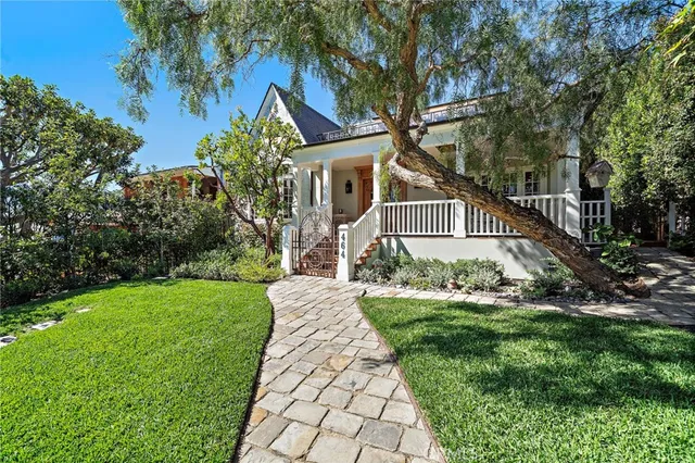a front view of a house with a yard and trees