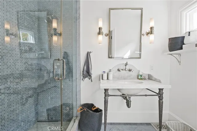 a bathroom with a granite countertop sink a mirror and shower