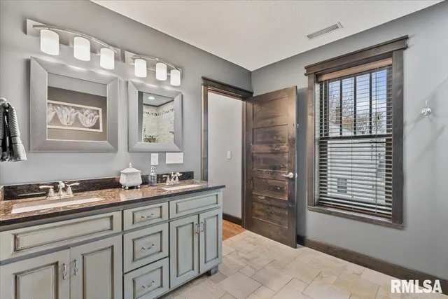 a bathroom with a granite countertop toilet a sink and a mirror