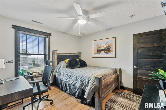 a bedroom with a large bed and a chandelier