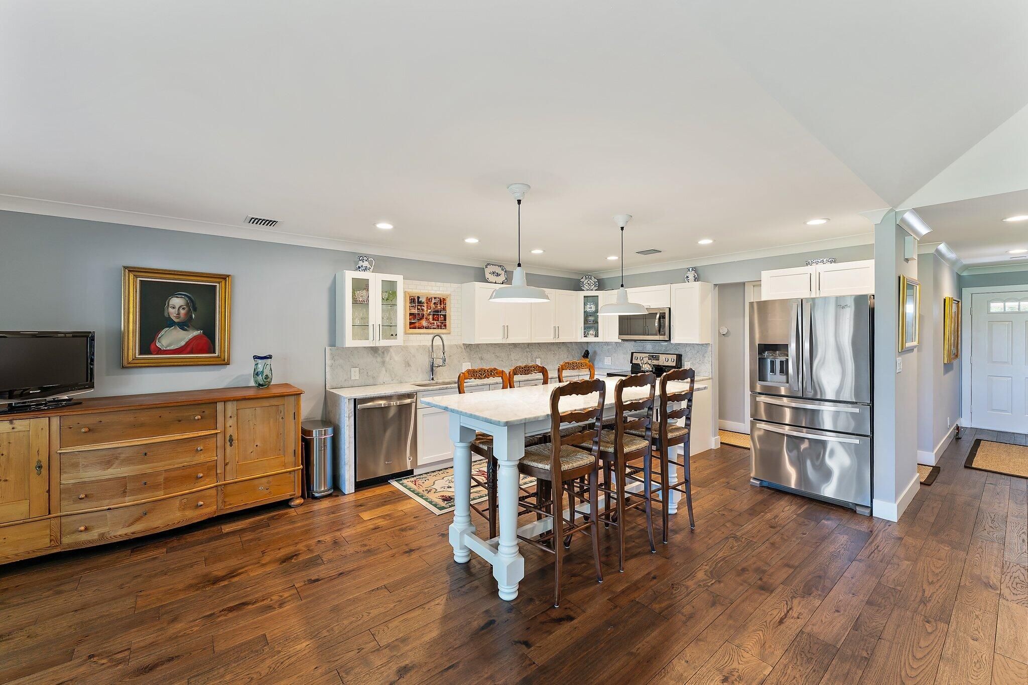 19101 Southeast Sea Turtle Court, Unit 202 Jupiter, FL 33469 - Photo 12 of 35 a kitchen with stainless steel appliances a dining table chairs stove and refrigerator