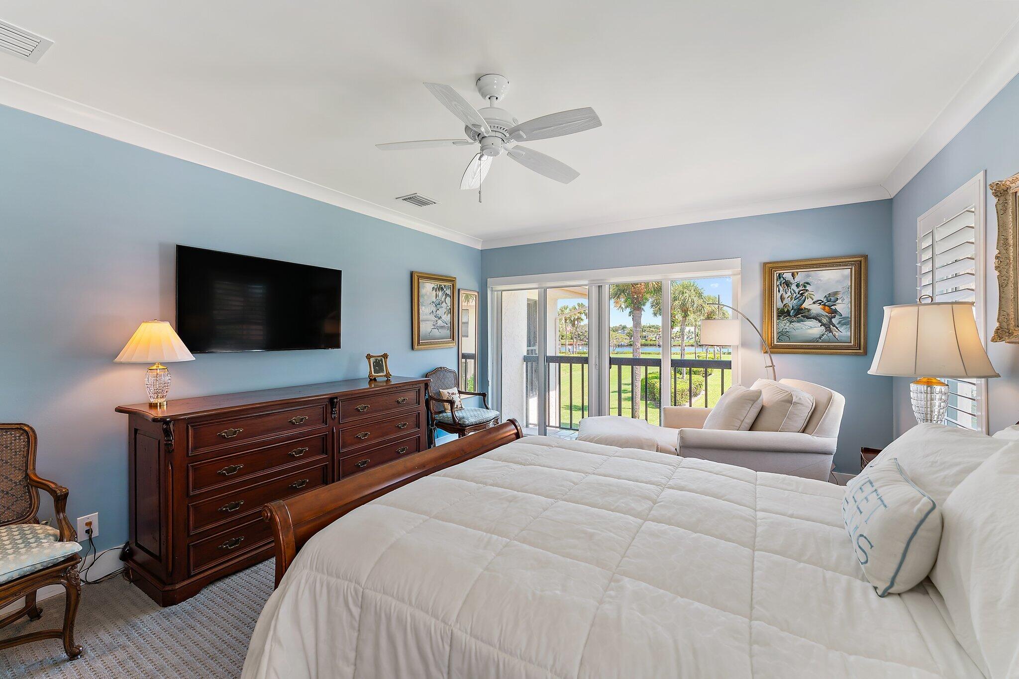 19101 Southeast Sea Turtle Court, Unit 202 Jupiter, FL 33469 - Photo 25 of 35 a bedroom with a bed and a flat screen tv on dresser