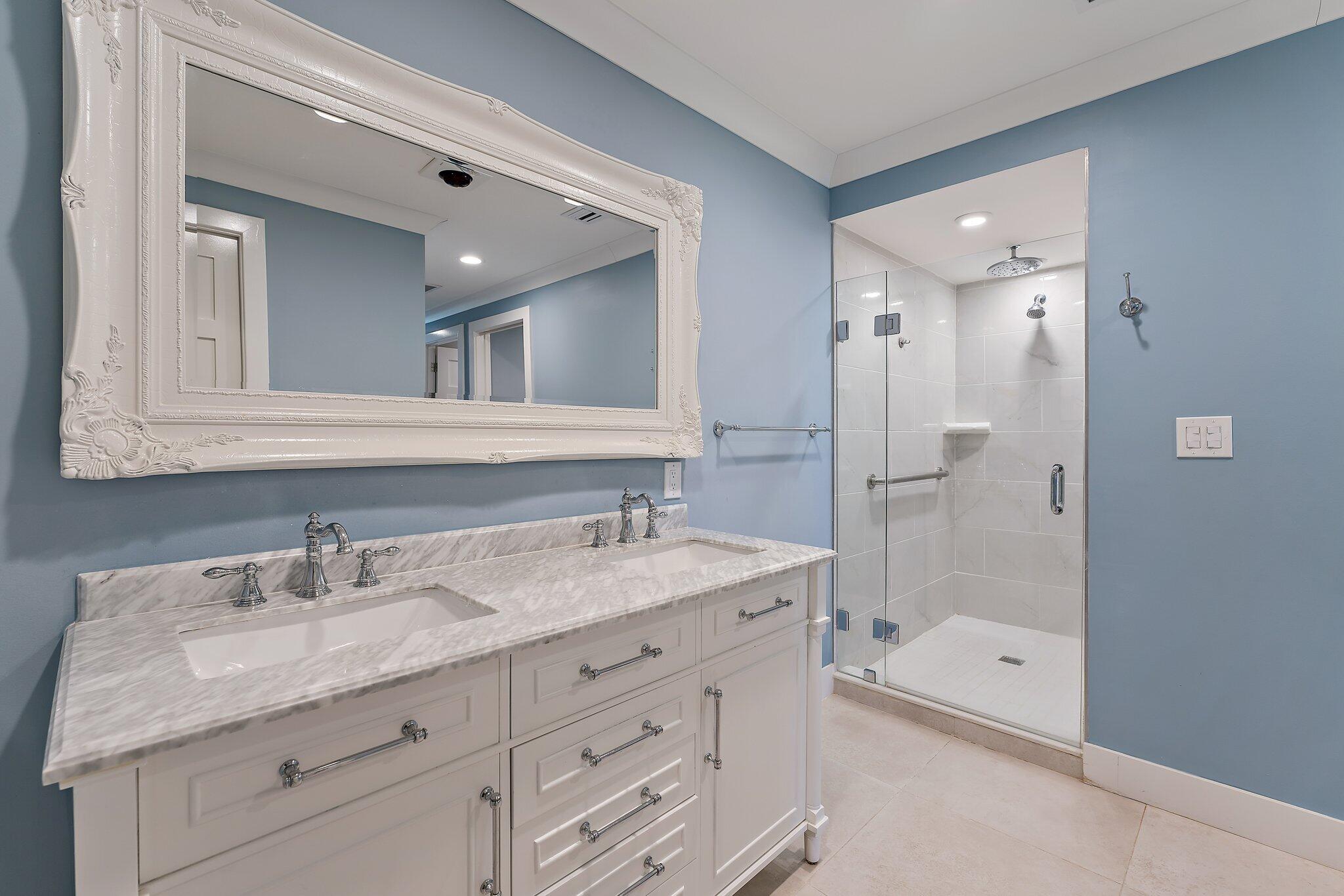19101 Southeast Sea Turtle Court, Unit 202 Jupiter, FL 33469 - Photo 29 of 35 a bathroom with a granite countertop sink mirror and shower