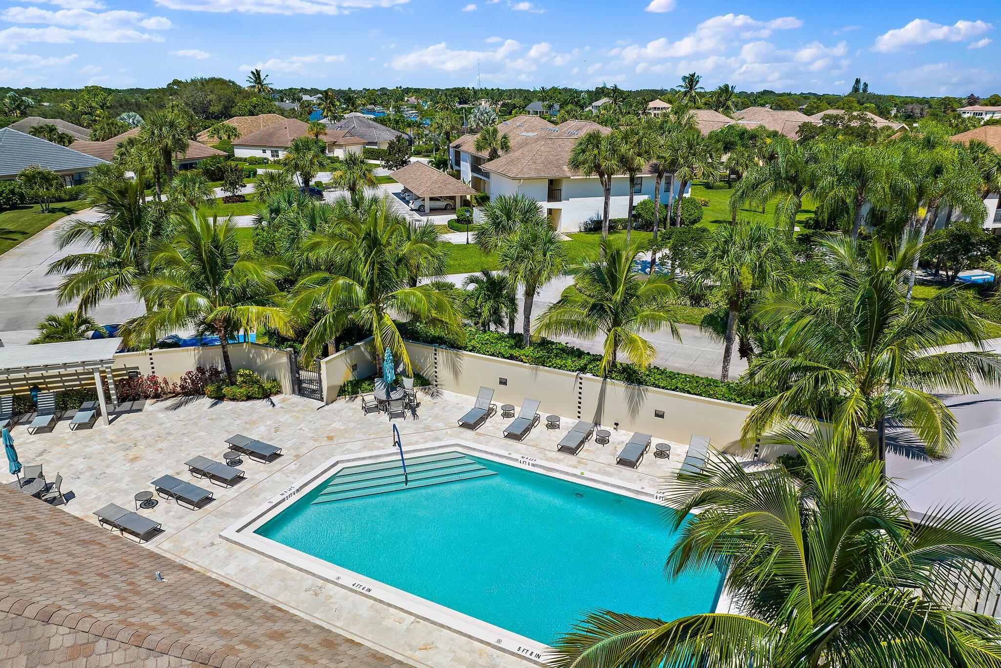 19101 Southeast Sea Turtle Court, Unit 202 Jupiter, FL 33469 - Photo 33 of 35 a view of a swimming pool with a yard and lake view